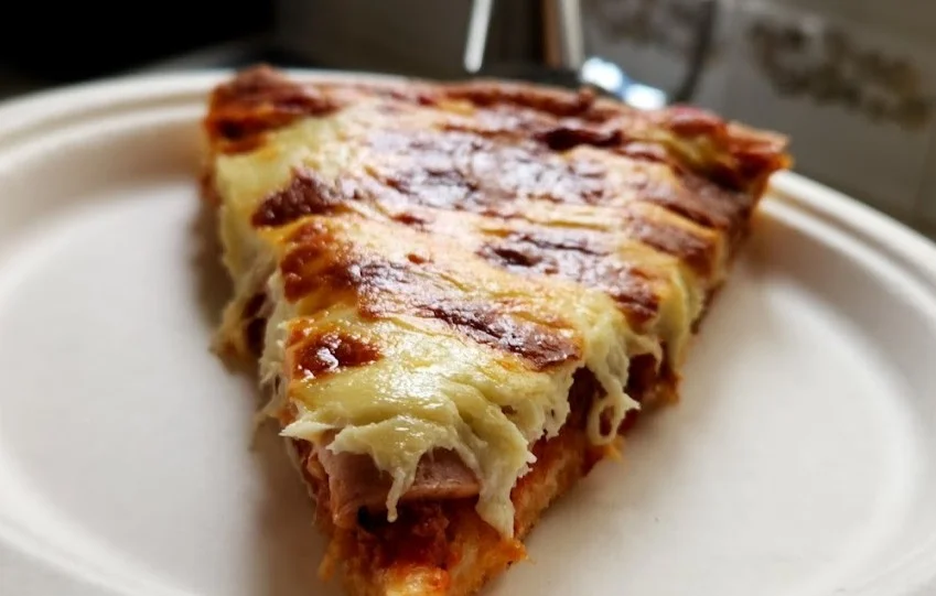 Freshly baked pizza with flavorful sauce at Acadia Pizza